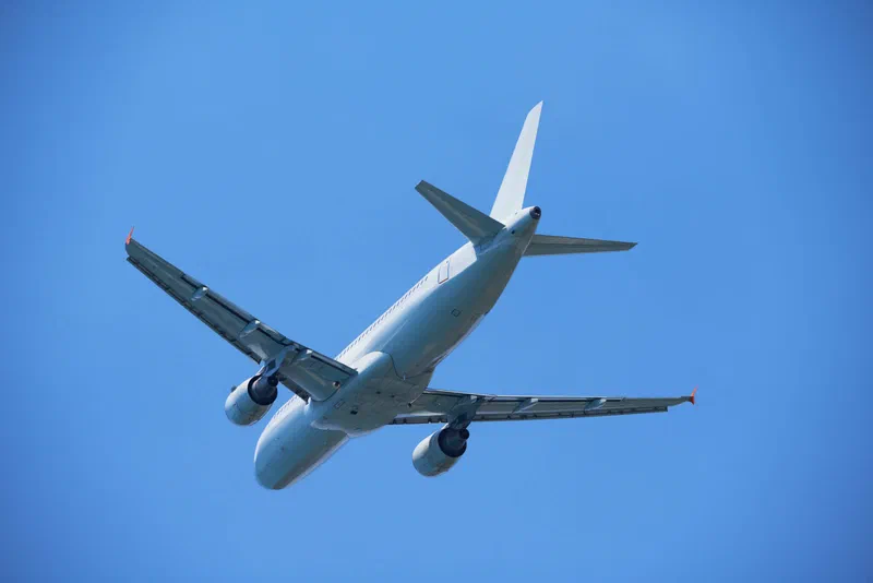 Cargo airplane climbing into a clear blue sky