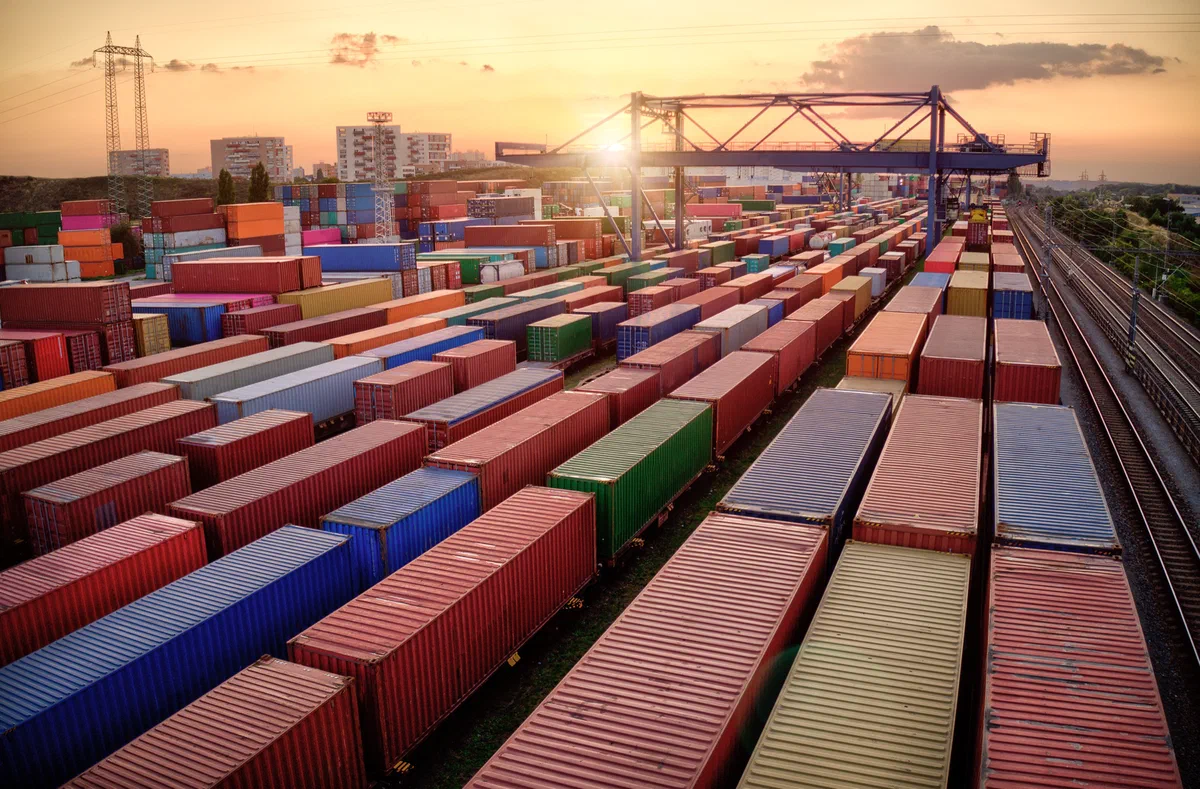 Aerial view of a sprawling container and rail yard at sunset