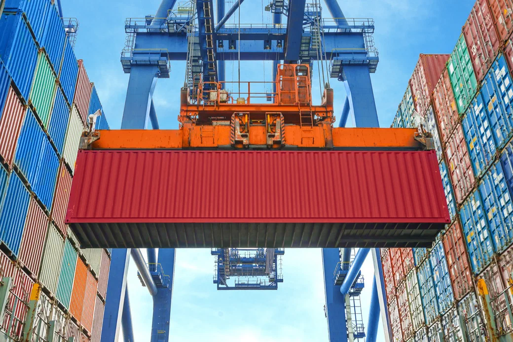A ship-to-shore crane lifting a shipping container at a port