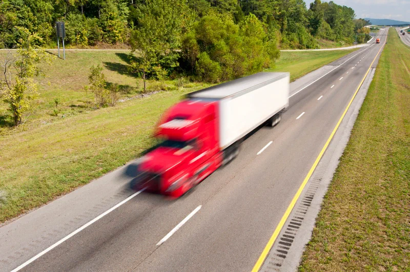 Semi truck speeding down an interstate highway